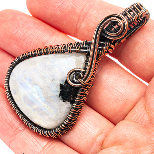 Teardrop wire-wrapped moonstone pendant with black tourmaline accents, oxidized copper bail