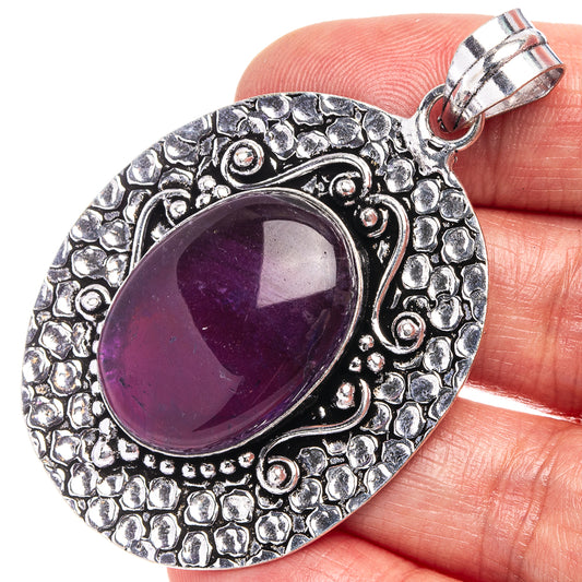 Amethyst oval pendant in silver-tone German silver with textured border and top bail