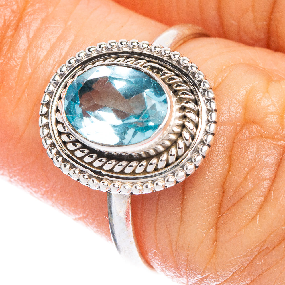 Sterling silver ring with oval blue topaz, detailed halo setting