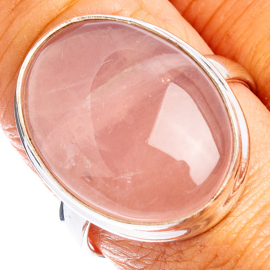 Oval rose quartz cabochon ring with polished .925 sterling silver bezel on finger