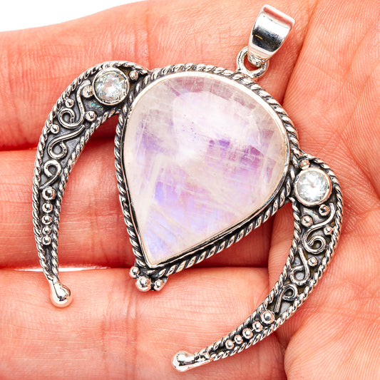 Teardrop moonstone pendant in silver with round blue accents on bail