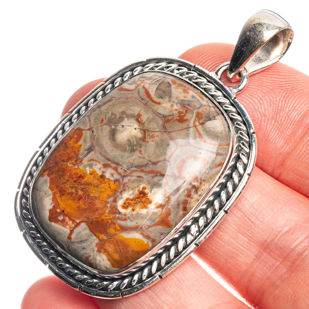 Sterling silver oval pendant with marbled rhyolite in amber, rust, and white