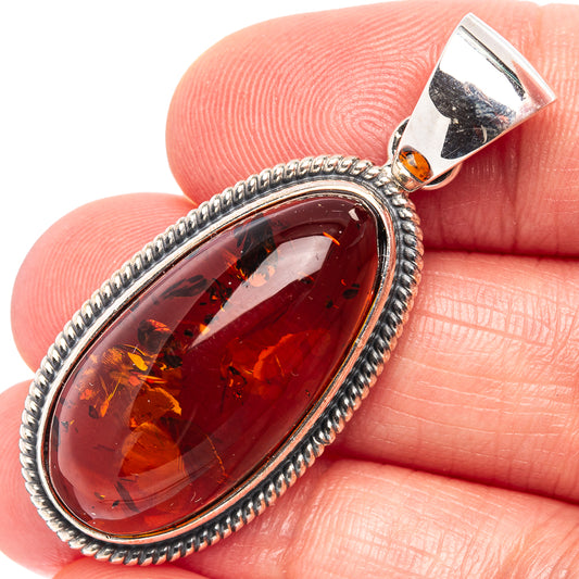 Oval Baltic amber pendant in .925 sterling silver bezel, dark red-brown amber cabochon.
