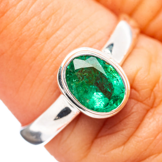 Sterling silver emerald ring with oval green gemstone, close-up on setting