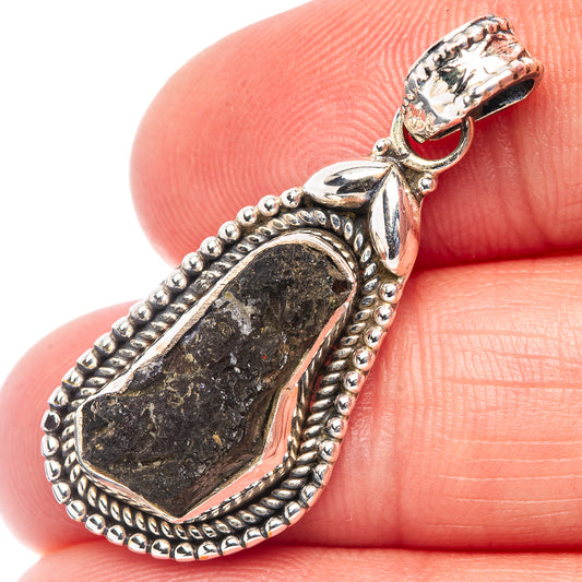 Sterling silver teardrop pendant with dark green moldavite stone and textured bezel