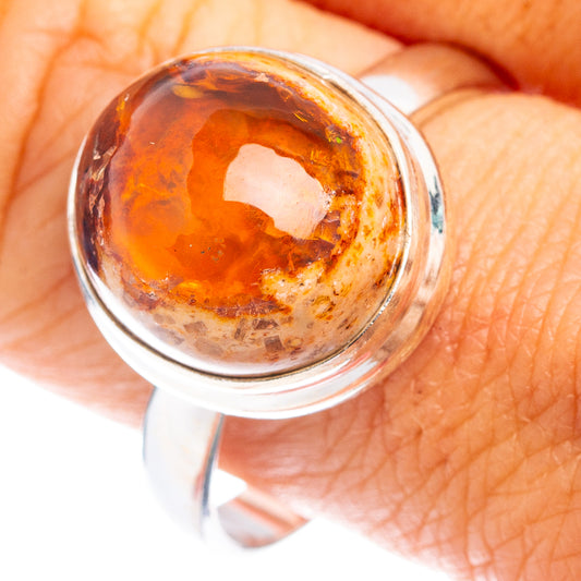 Oval fire opal gemstone set in sterling silver ring, orange-brown with dark specks