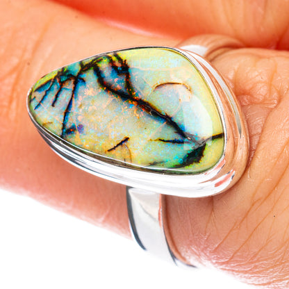 Sterling silver oval opal ring with blue-green iridescent stone, polished bezel.