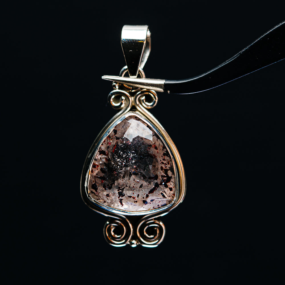 Sterling silver teardrop pendant with faceted lepidocrocite stone and ornate swirl bail