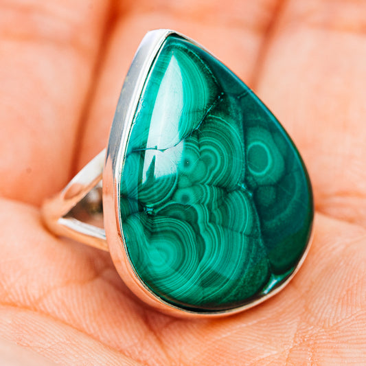 Teardrop malachite cabochon ring on a silver band, side view with green stone pattern.
