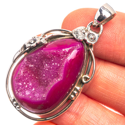 Pink drusy agate pendant with oval cabochon in silver-tone bezel and ornate bail