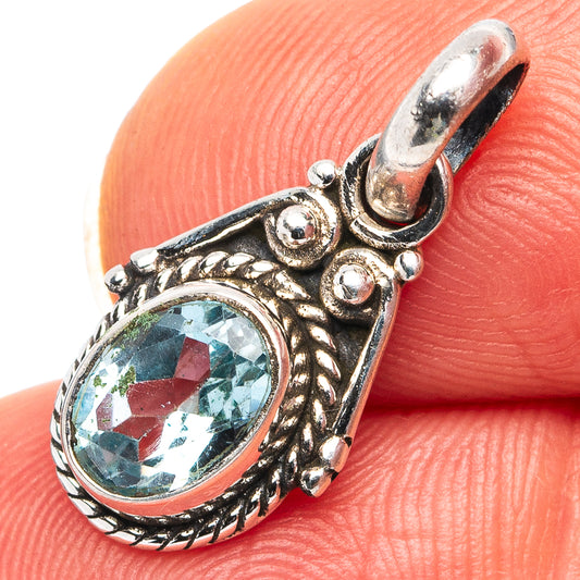Sterling silver pendant with oval blue topaz gemstone in ornate bezel setting