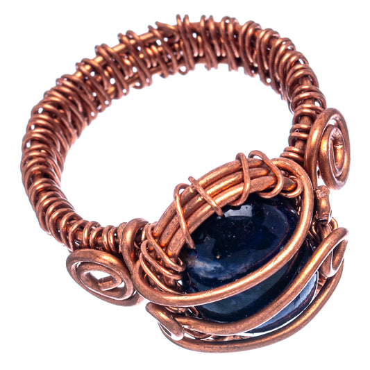 Oxidized copper wire-wrap ring showing dark blue cabochon with wrapped bands