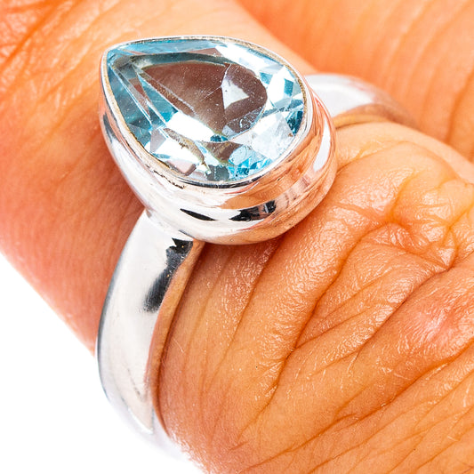Polished .925 sterling silver ring with oval blue topaz centerpiece, faceted gemstone close-up.