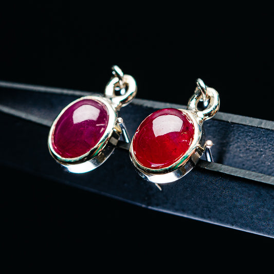 Oval red ruby drop earrings in .925 sterling silver, with secure hook backs.