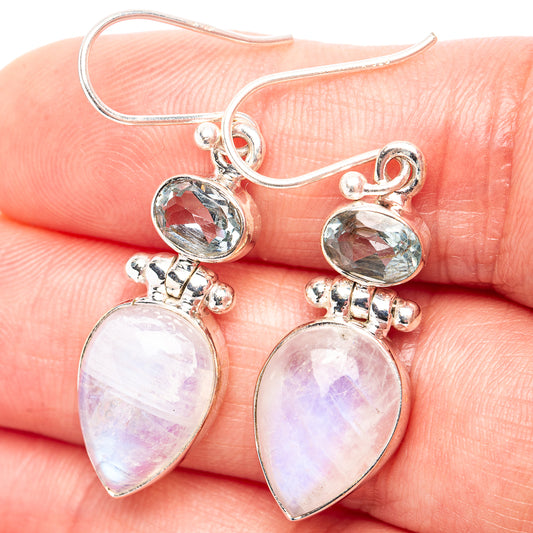 Sterling silver drop earrings with blue oval topaz and pear moonstone in prong settings