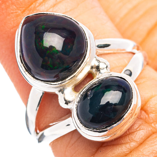 Sterling silver ring with paired oval black opal cabochons, side view on finger