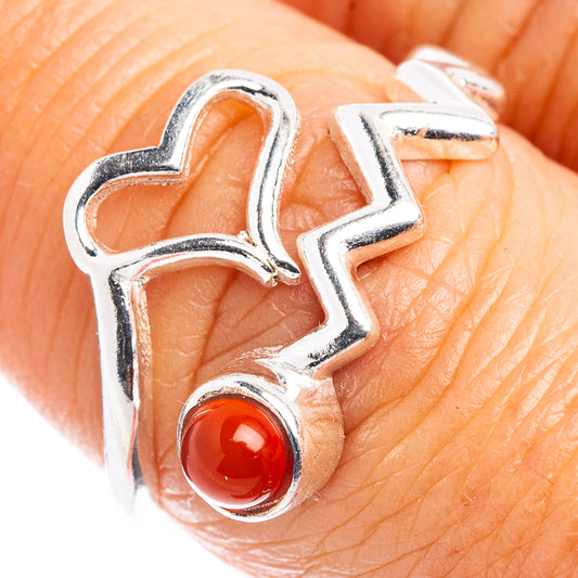 Sterling silver heart ring with red carnelian cabochon, close-up on finger