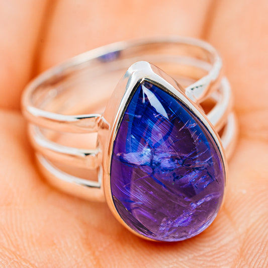 Blue pear-shaped gemstone on polished sterling silver ring with band, side view
