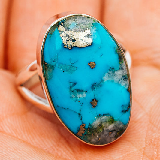 Oval turquoise stone ring with silver bezel, blue cabochon with natural veining and specks