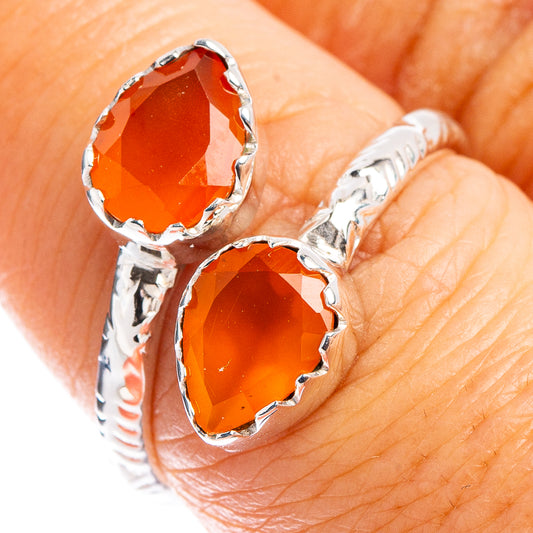 Close-up sterling silver ring with two orange-red faceted carnelian gemstones