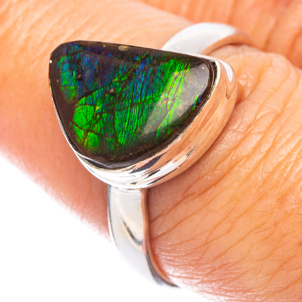 Ammolite gemstone ring with green iridescent stone in polished silver bezel