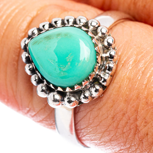 Sterling silver turquoise cabochon ring close-up on finger, ornate bead setting