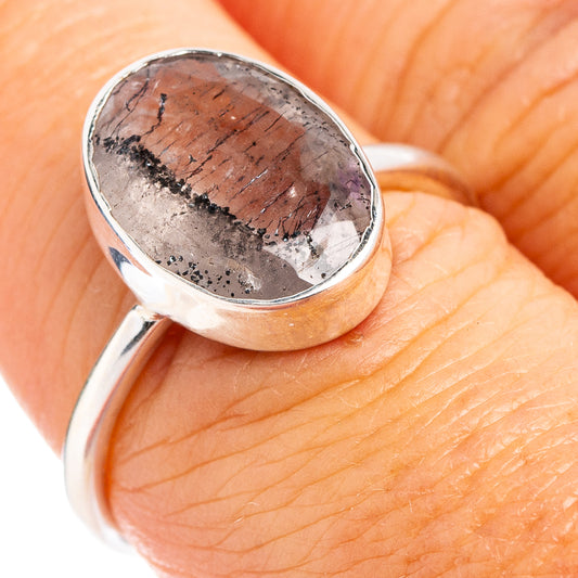 Sterling silver ring with oval gray gemstone, close-up on finger