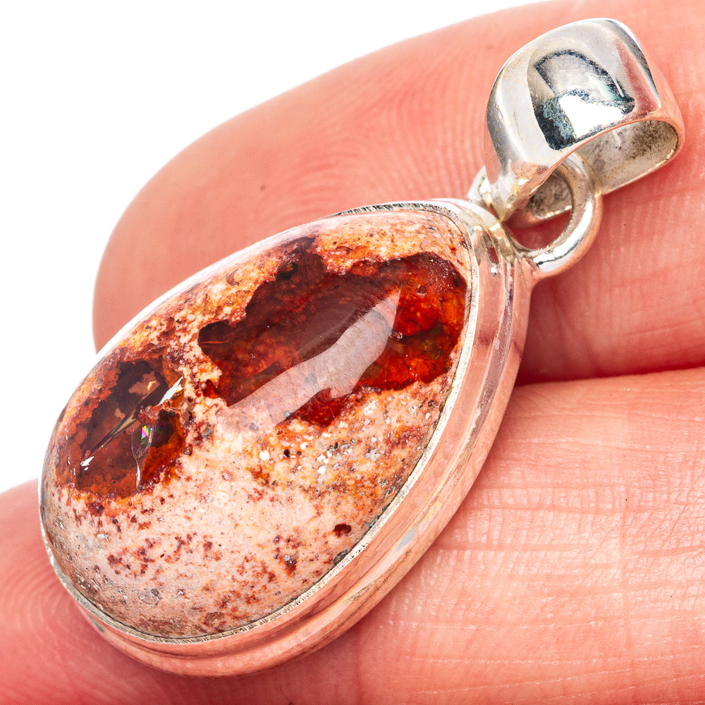Close-up oval fire opal pendant with sterling silver bail and red orange mottled cabochon
