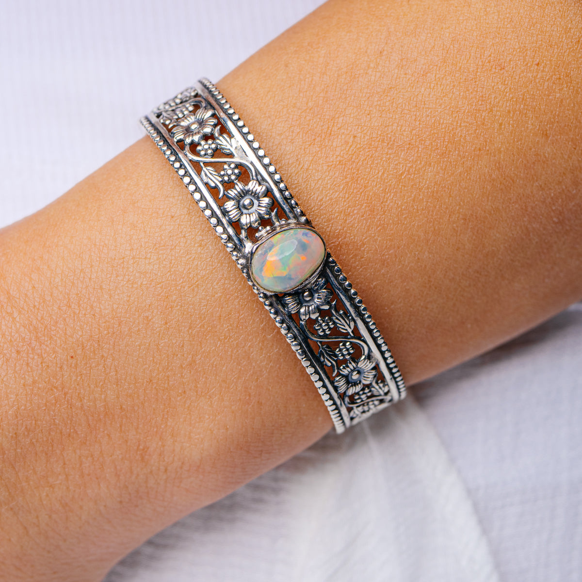 Sterling silver cuff bracelet with ornate engraved sides and round opal cabochon