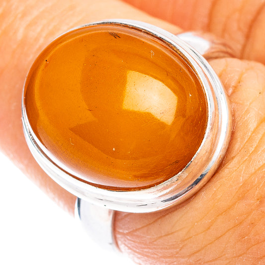 Sterling silver ring with round orange amber cabochon bezel