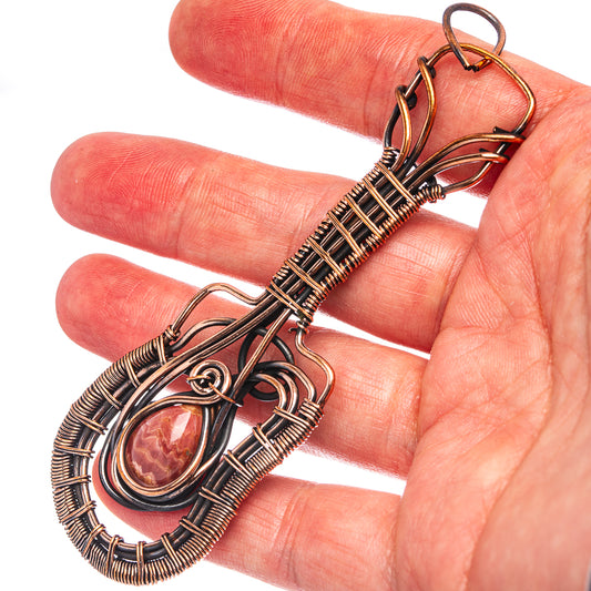 Oxidized copper wire wrap pendant with oval rhodochrosite stone, close-up on bail loops