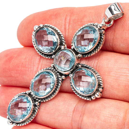 Sterling silver cross pendant with round blue topaz gemstone settings, hinged bail