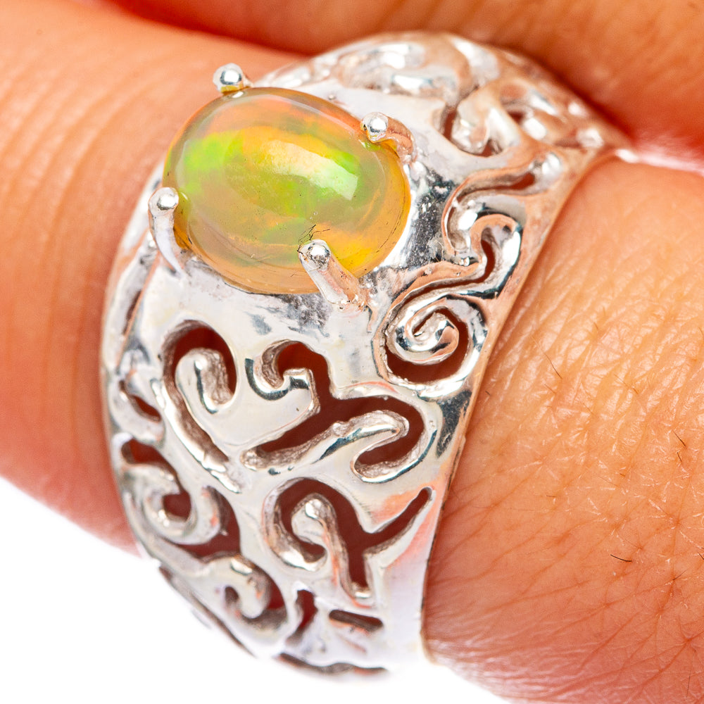 Sterling silver filigree ring with oval opal gemstone, ornate engraved band.