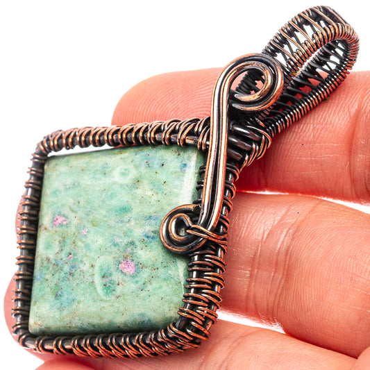 Oxidized copper wire-wrap pendant with square light green stone and pink flecks