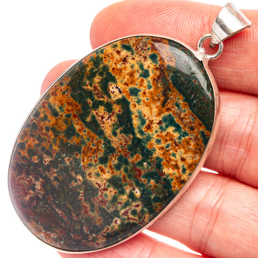 Oval bloodstone pendant with silver-plated frame and bail, close-up speckled pattern