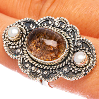 Oval brown/orange cabochon ring with silver filigree and two white opal stones