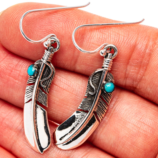 Turquoise bead feather earrings with ornate silver hooks and dangling feather charms