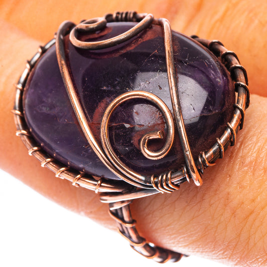 Amethyst wire-wrapped ring with oxidized copper band and purple oval stone
