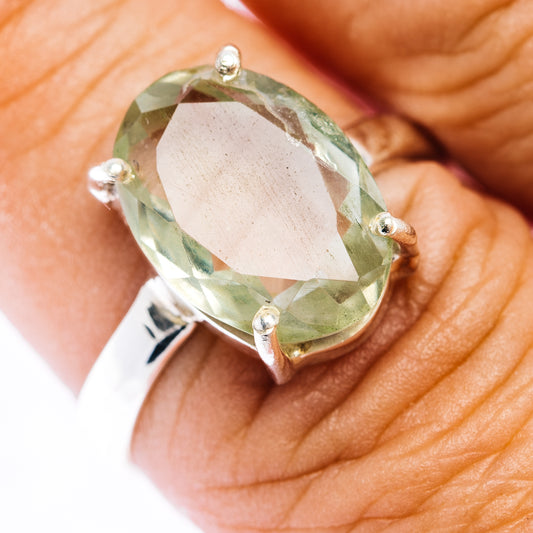 Oval faceted prasiolite ring with four-prong silver setting, close-up top view
