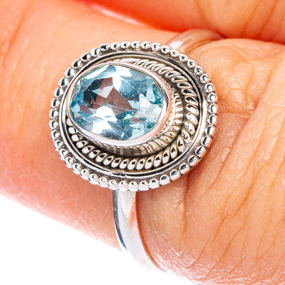 Sterling silver ring with oval blue topaz and ornate bead and rope border
