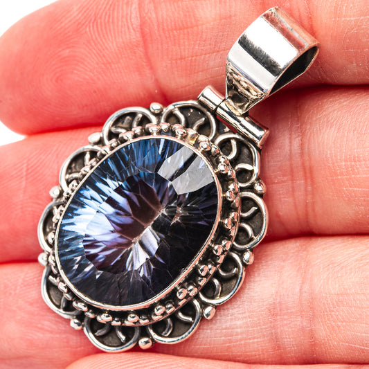 Sterling silver pendant with oval blue gemstone and ornate filigree bezel, top bail