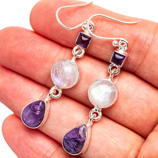 Sterling silver drop earrings with moonstone discs and purple amethyst teardrops on hand