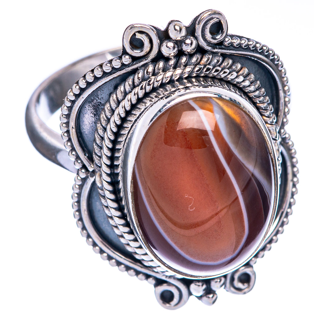 Sterling silver ring with oval brown agate, braided rope border, and decorative side loops