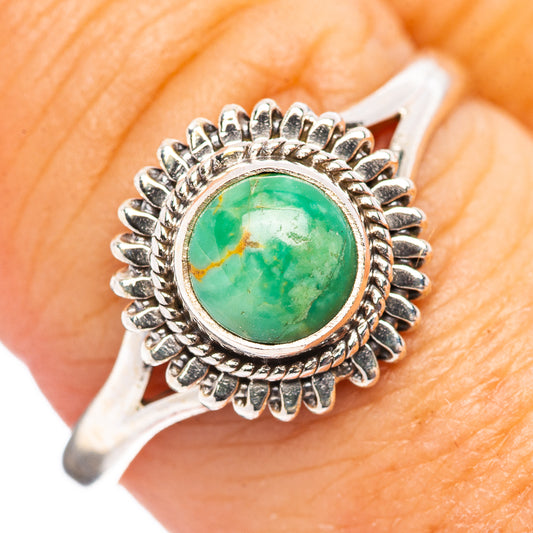 Sterling silver turquoise ring on finger, oval green cabochon with spiked bezel