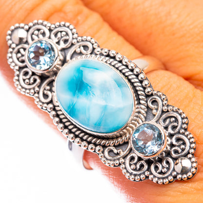 Silver filigree ring with oval light-blue larimar center and two round blue accents