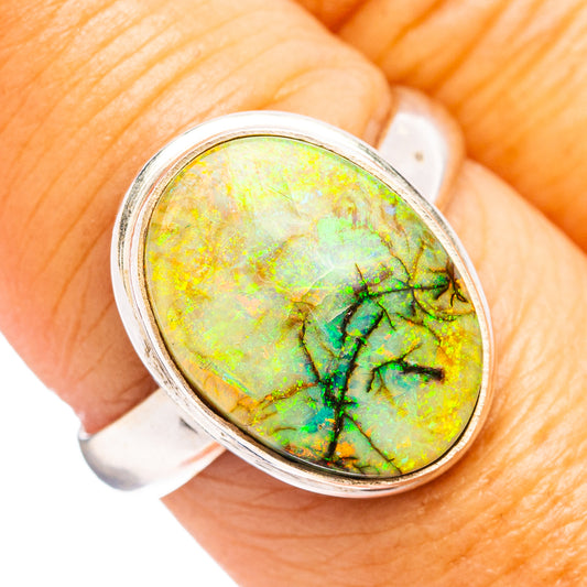 Oval opal ring with yellow-green stone and round-cut silver bezel setting