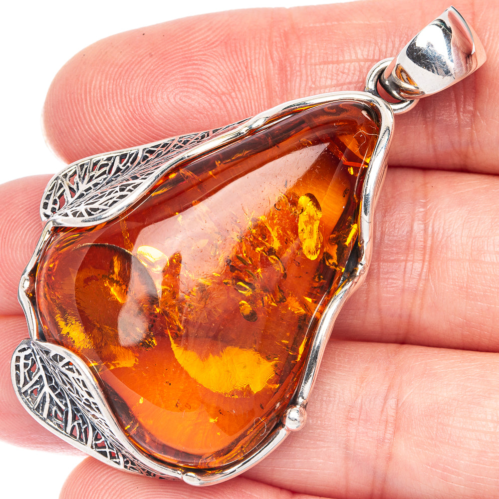 Teardrop Baltic amber pendant in 925 sterling silver with ornate side filigree and bail