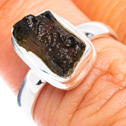 Sterling silver ring with rough dark moldavite stone on finger, size 6