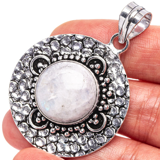 Round German-silver pendant with pale moonstone cabochon and ornate beadwork frame