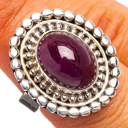 Sterling silver ring with oval deep purple gemstone in scalloped bezel